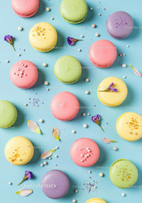 Colorful macarons scattered on bright pastel background