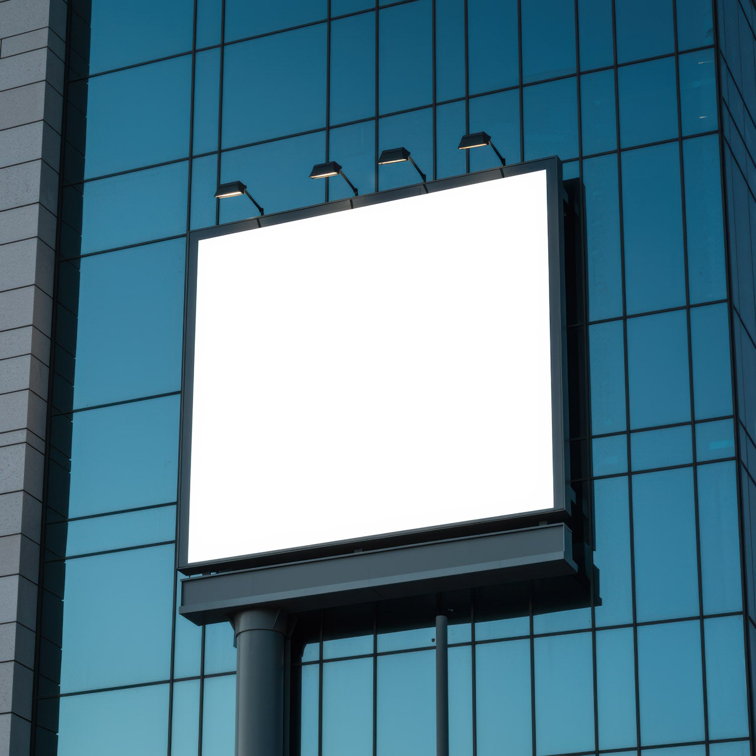 Empty illuminated billboard on modern office building facade
