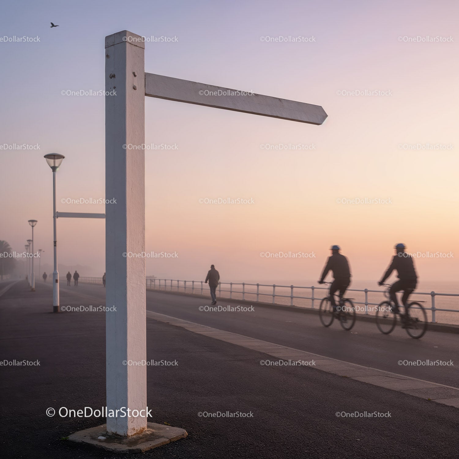 Cyclists and pedestrians on foggy seafront promenade