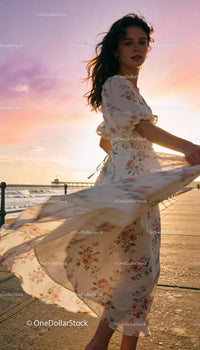 Young woman dancing in floral dress at sunset by the sea