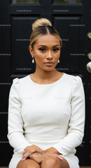 Elegant woman with blonde bun in white dress