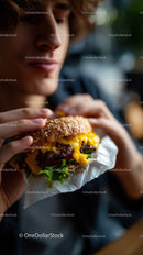 Close-up of a Juicy Cheeseburger Being Eaten by a Man