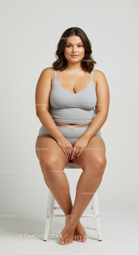 Confident Plus Size Woman Sitting on a White Stool in Casual Wear
