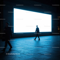 Silhouettes walking past bright urban billboard at night