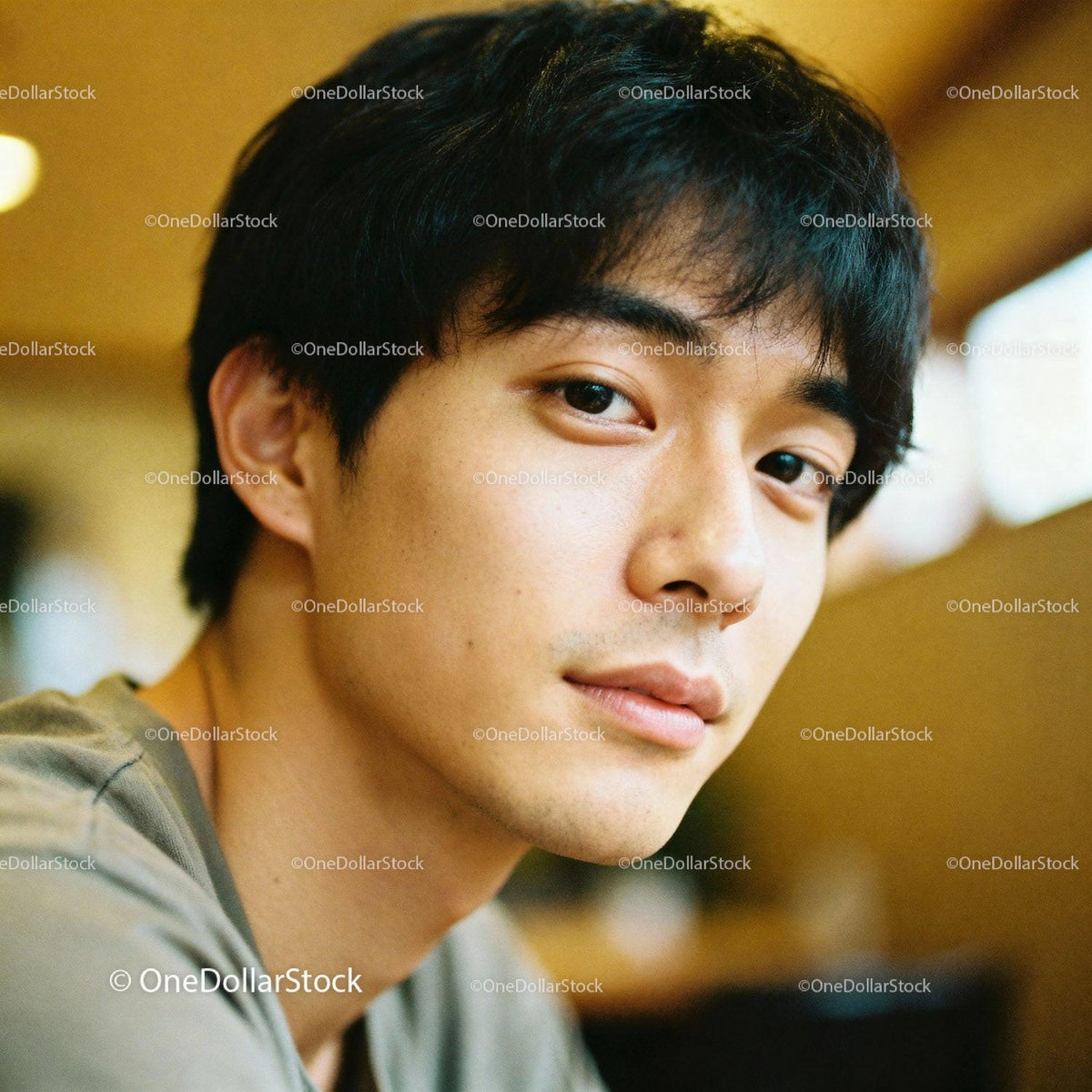 Young man with thoughtful expression in warm indoor light