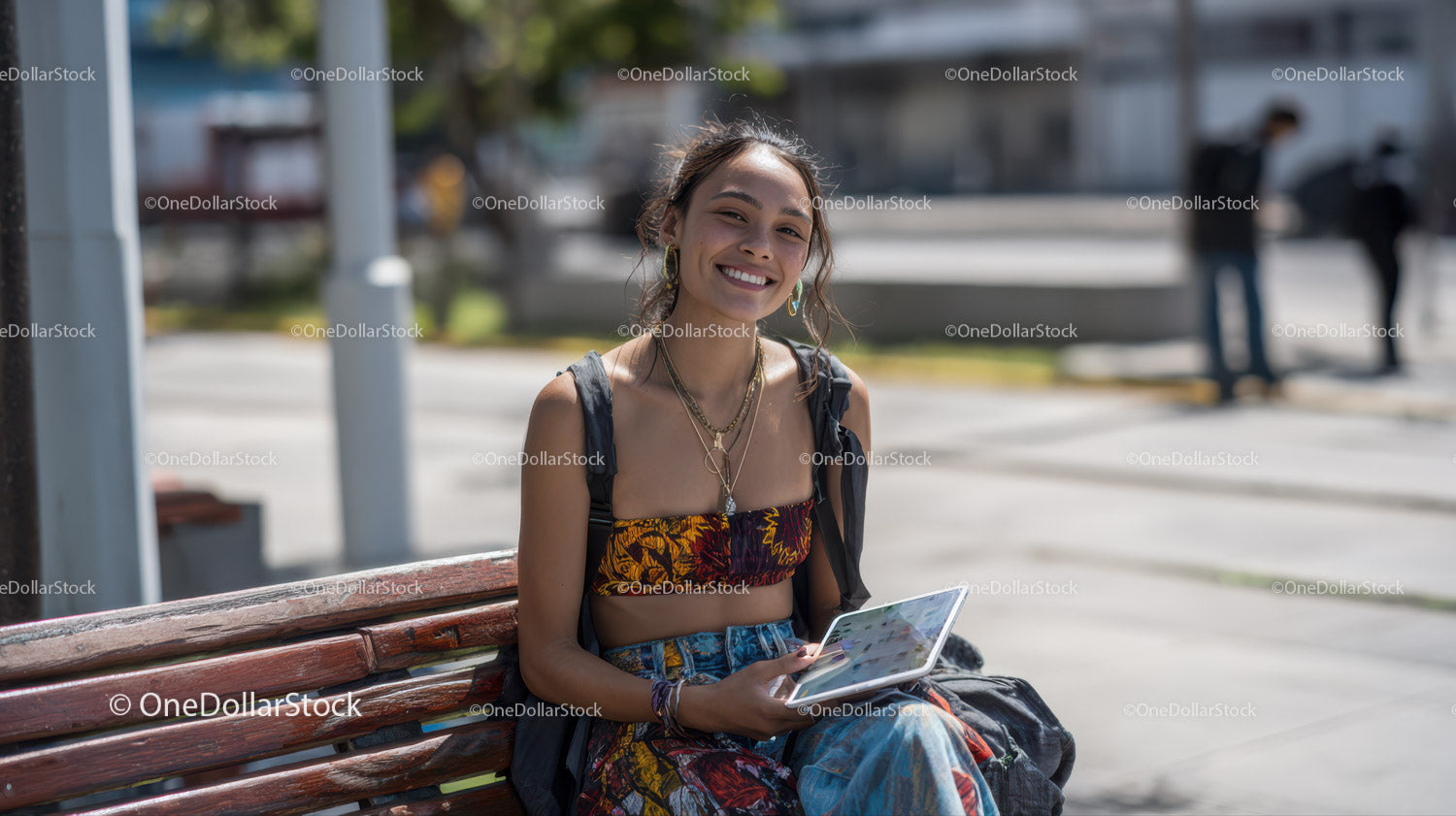 Young Woman Sitting on Park Bench Using Tablet in Urban Environment