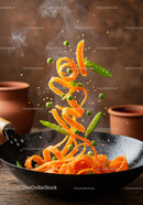 Fresh carrot ribbons stir-fried with green peas in wok