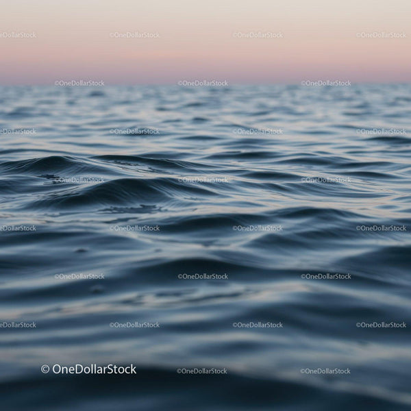 Spokojny ocean z łagodnymi falami o zachodzie słońca