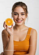Smiling Young Woman Holding Fresh Orange Slice for Healthy Lifestyle