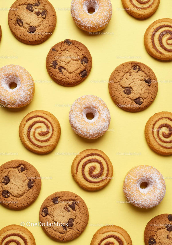 Różnorodne ciasteczka i pączki w cukrze pudrze na żółtym tle