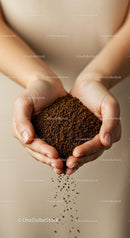 Close up of hands holding pouring coffee granules