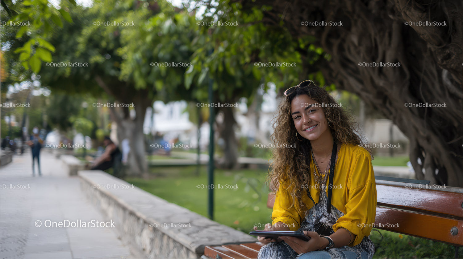 Young Woman Relaxing on Park Bench with Digital Tablet in Outdoor Setting