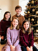 Smiling children gathered by festive Christmas tree