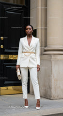 Confident woman in elegant white suit with gold accents