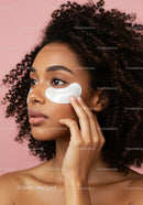 Beautiful Woman Applying Eye Patches with Curly Hair against Pink Background