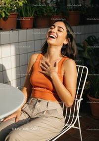 Joyful Woman Enjoying Sunny Day in Casual Outfit at Outdoor Cafe
