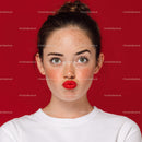 Expressive Woman with Freckles and Red Lips on Red Background