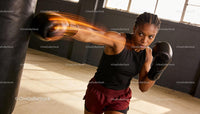 Focused woman delivering a powerful punch in boxing gym
