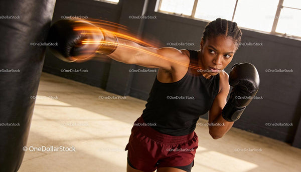 Focused woman delivering a powerful punch in boxing gym