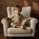 Toddler sitting comfortably on cozy beige armchair