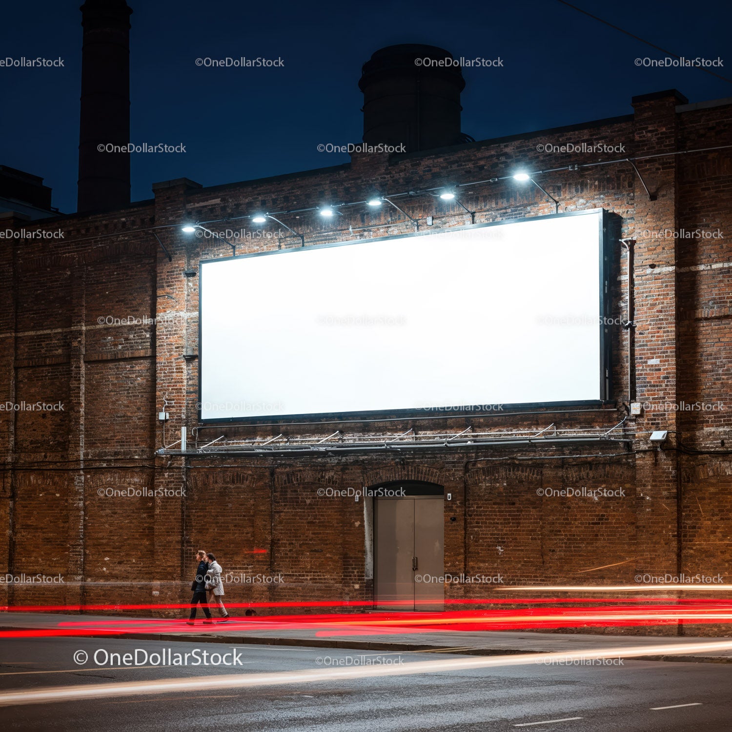 Para spacerująca nocą obok oświetlonego, pustego billboardu
