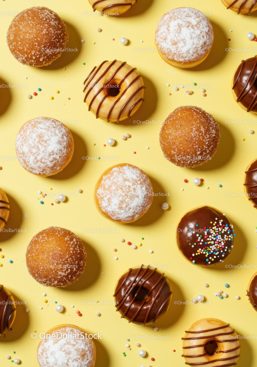 Assorted Frosted Donuts with Sprinkles on Yellow Background