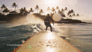 Surfer Riding Waves at Sunset Near Tropical Shore