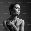 Serene woman embracing herself in soft light