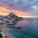 Scenic Coastal Village with Sunset Over Rocky Cliffs and Calm Ocean
