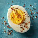 Hard Boiled Egg Sliced with Spices on Blue Background