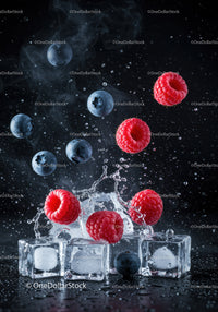 Fresh berries splashing over ice cubes on dark background