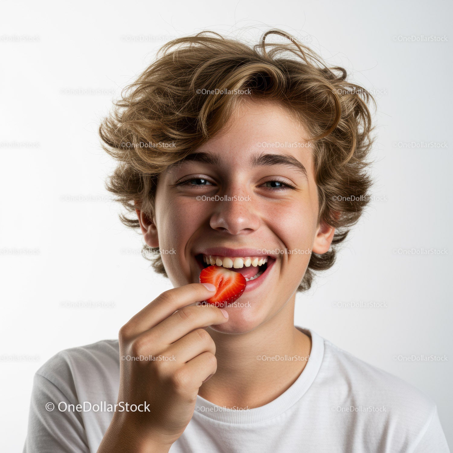 Joyful Boy Eating Strawberry with Bright Smile in Studio