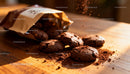 Freshly baked chocolate cookies spilling from brown bag