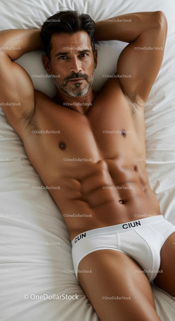 Fit man relaxing on bed in white underwear