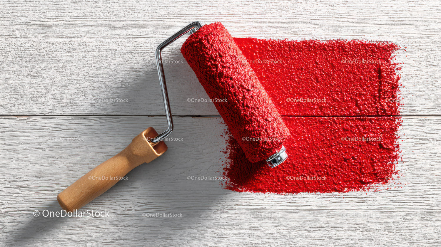 Red Paint Roller Spreading Bright Red Color on Wooden Surface
