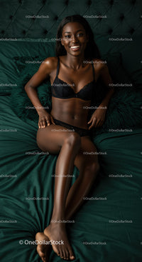 Smiling woman relaxing in black lingerie on bed