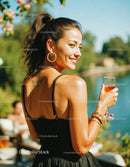 Woman with Champagne Glass Wearing Black Dress Outdoors in Summer