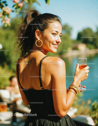 Woman with Champagne Glass Wearing Black Dress Outdoors in Summer