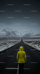 Lonely Traveler in Yellow Jacket on Snow-Covered Road