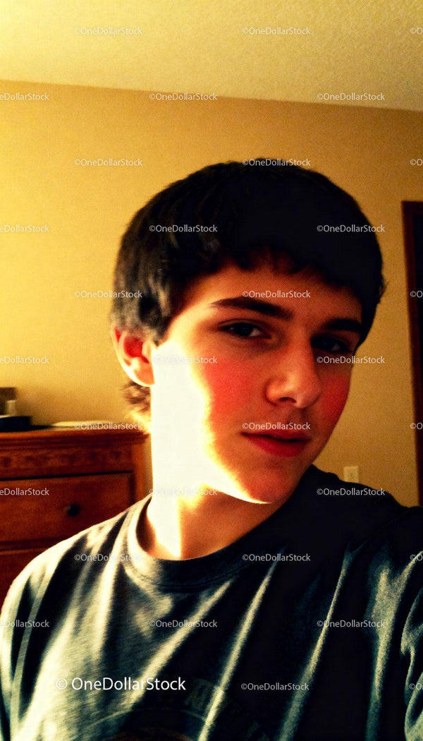 Nastolatek pozujący w pomieszczeniu przy ciepłym, miękkim świetle