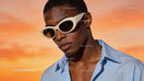 Young man wearing stylish sunglasses in warm sunlight
