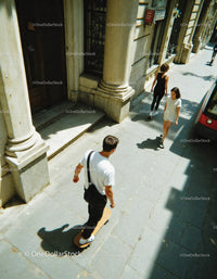 Skateboarding Youths Walking on Sunny City Street Sidewalk