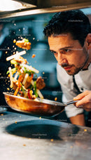 Focused chef tossing stir fry in busy kitchen