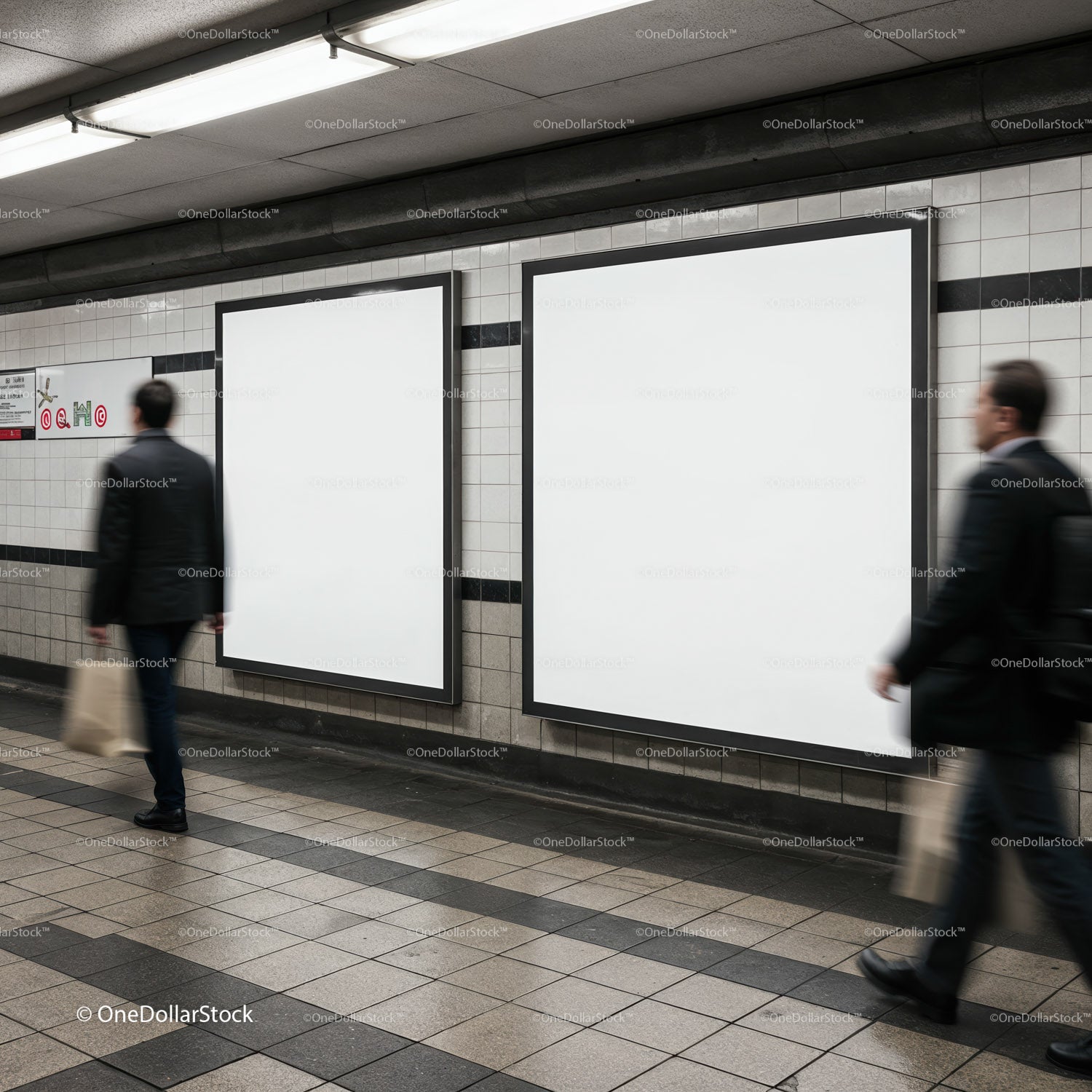 Business commuters passing blank poster frames in subway