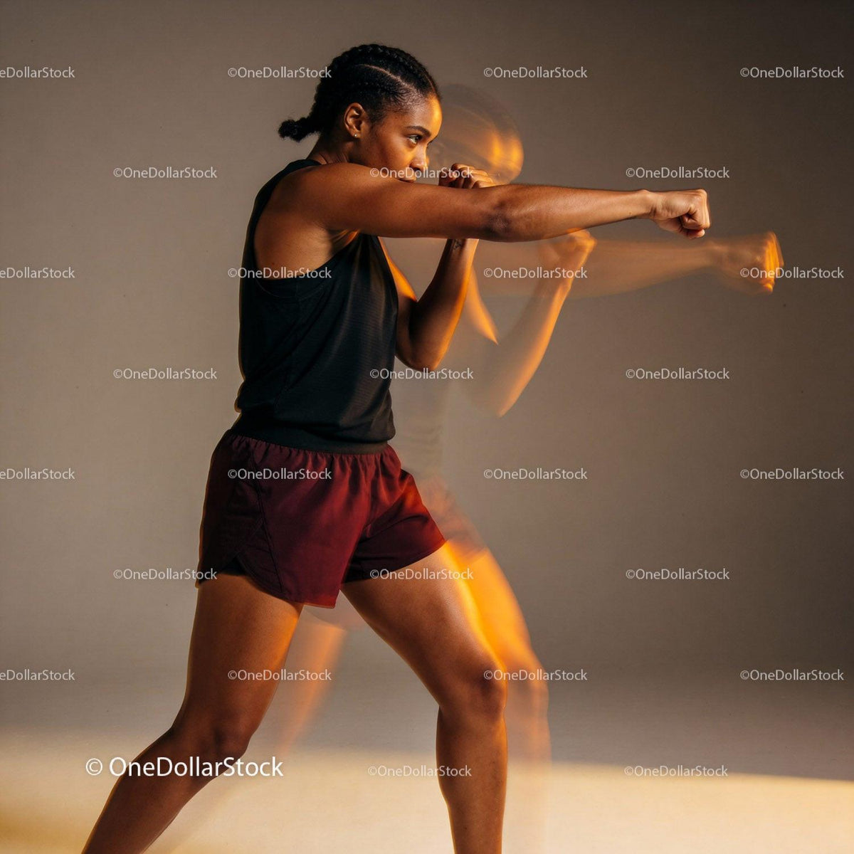 Focused woman practicing boxing punch in motion