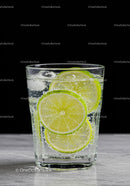 Refreshing sparkling water with lime slices on marble