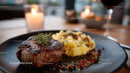 Gourmet Steak with Mashed Potatoes on Elegant Plate in Fine Dining Setting