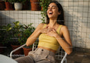 Joyful Woman Laughing Outdoors in Bright Terrace with Green Plants