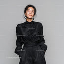Elegant Woman in Black Outfit with Statement Earrings Studio Portrait