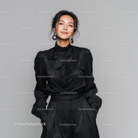 Elegant Woman in Black Outfit with Statement Earrings Studio Portrait